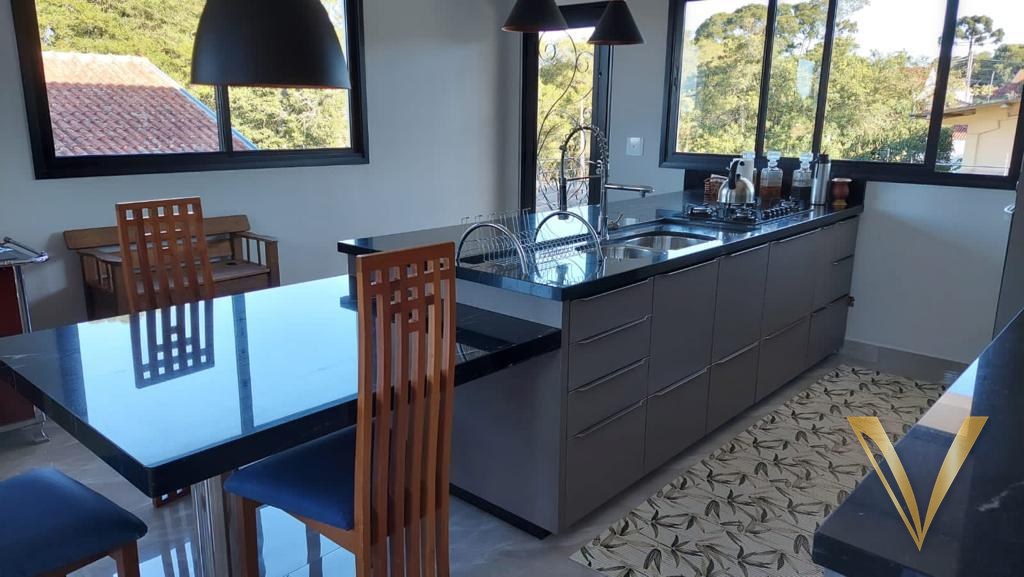 Vista da cozinha integrada à mesa de jantar com tampo escuro