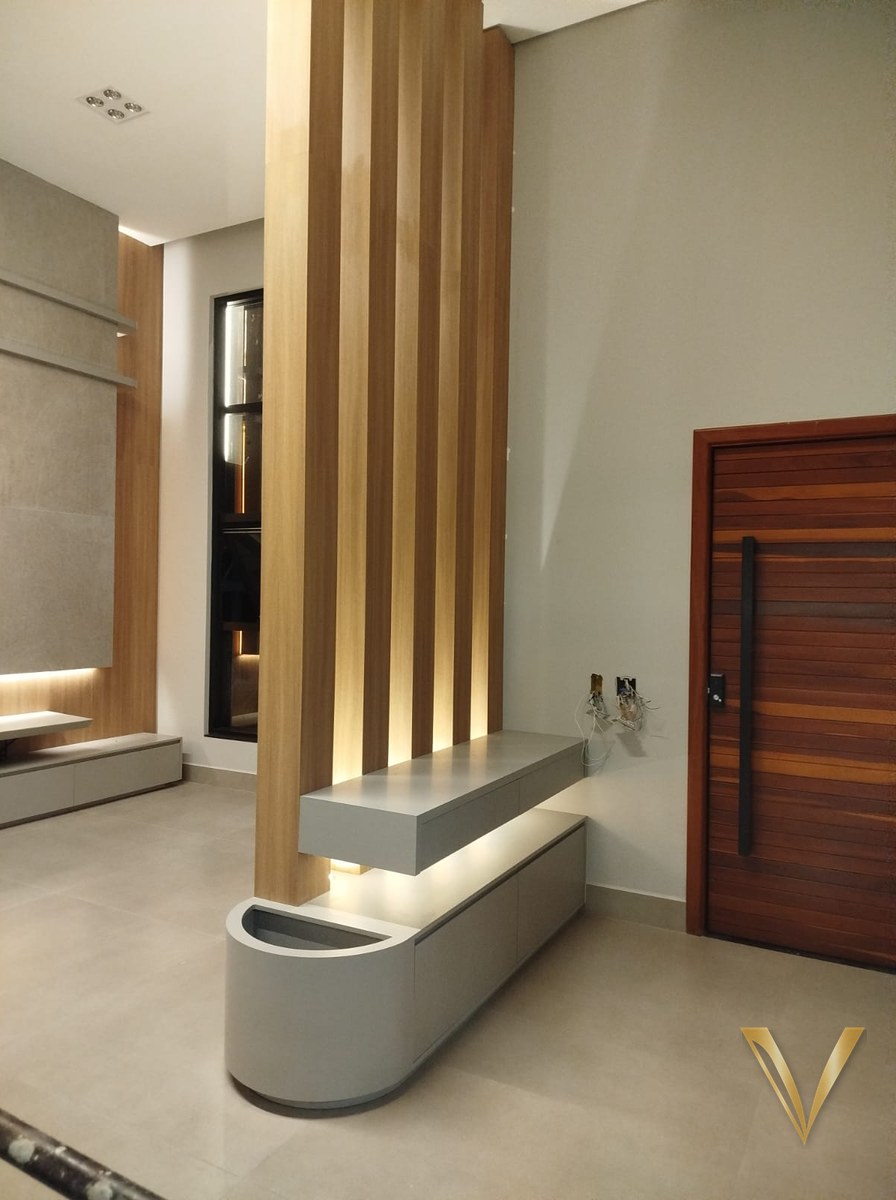 Aparador flutuante em laca cinza com rasgo de luz e jardineira curva no hall