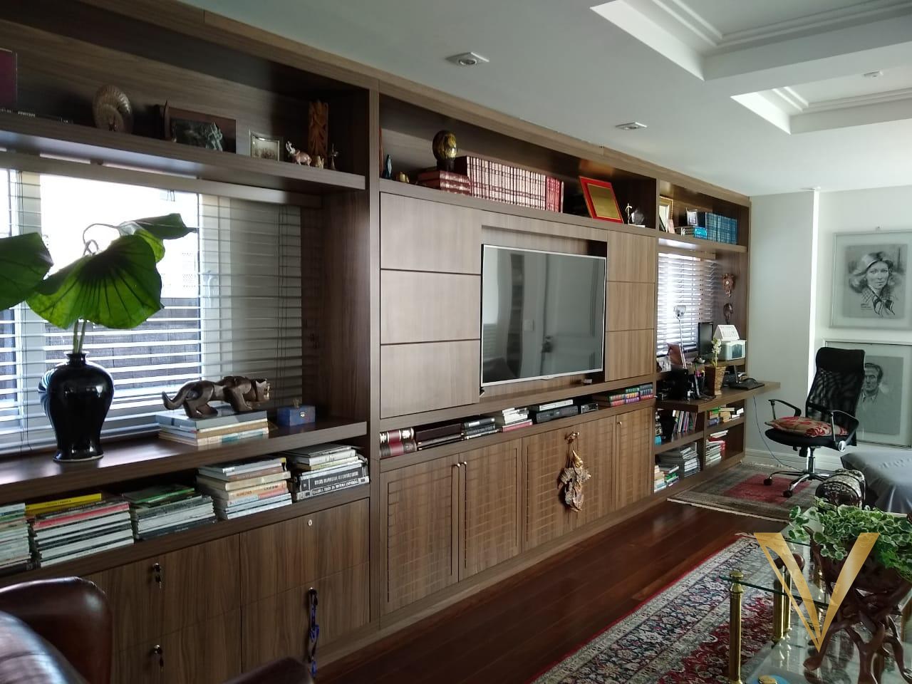 Parede completa de marcenaria em madeira com biblioteca, painel de TV e armários