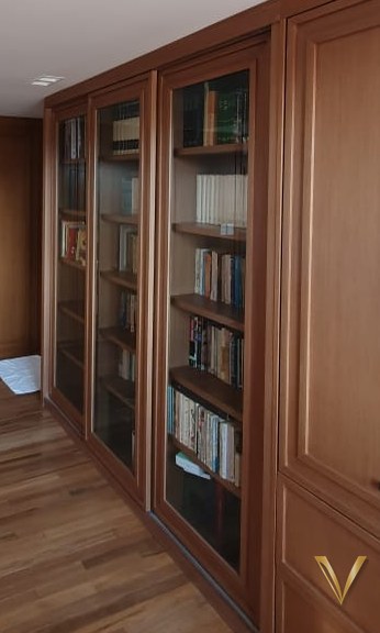 Detalhe aproximado das vitrines em vidro da biblioteca em madeira nobre