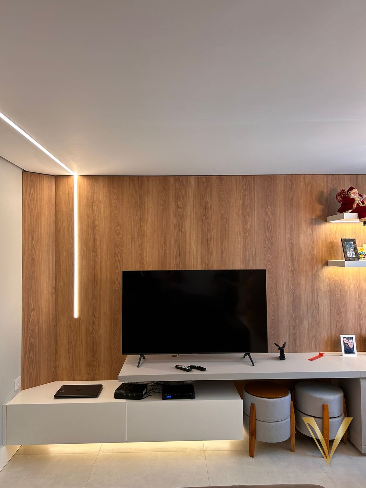 Painel de madeira do piso ao teto com rack branco suspenso e rasgo de LED