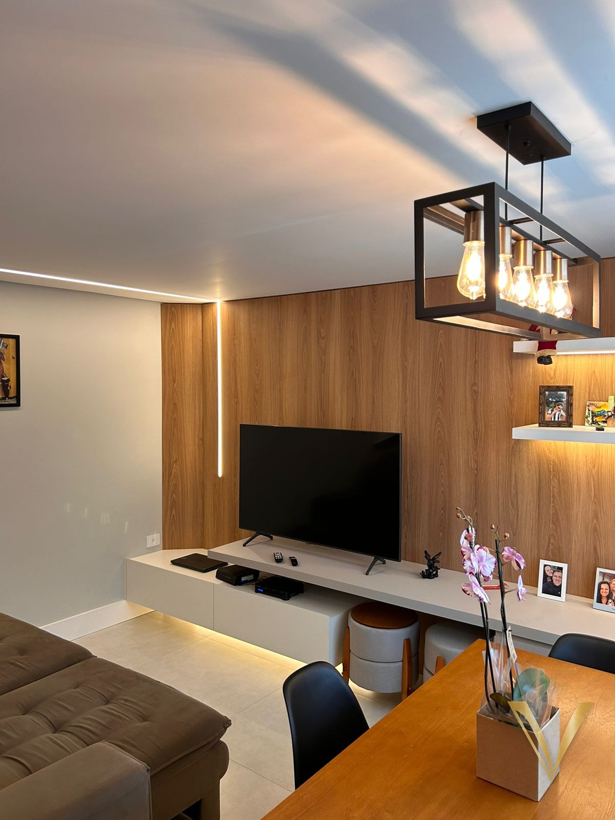 Living integrado com painel de madeira, rack suspenso e mesa de jantar