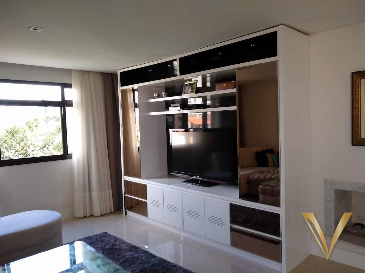 Estante de living em laca branca com vidro fumê, espelho bronze e prateleiras iluminadas