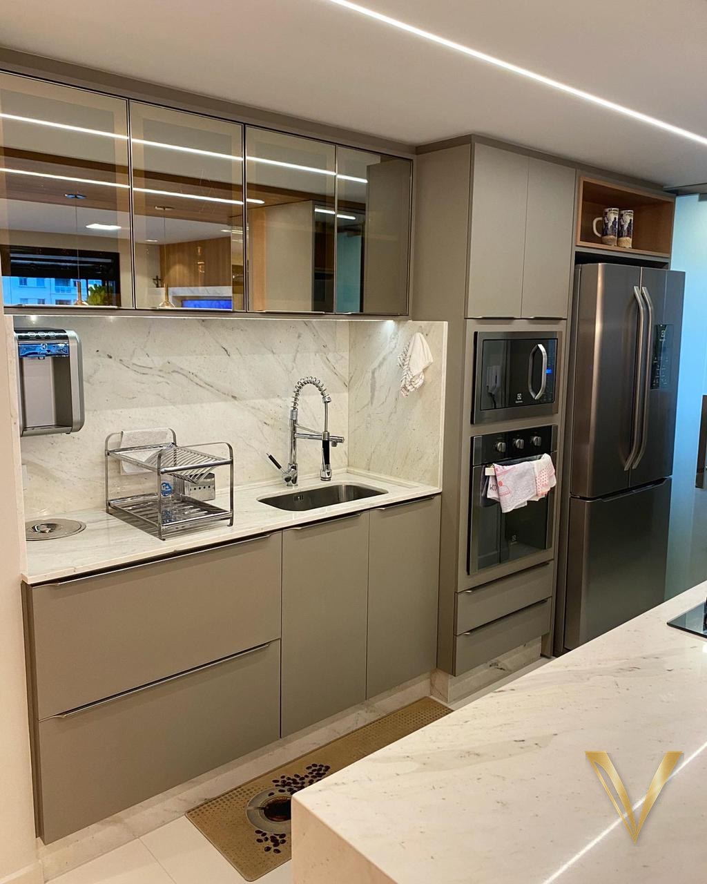 Cozinha em laca fendi com frontão em mármore branco, aéreos em vidro reflecta e torre de eletros