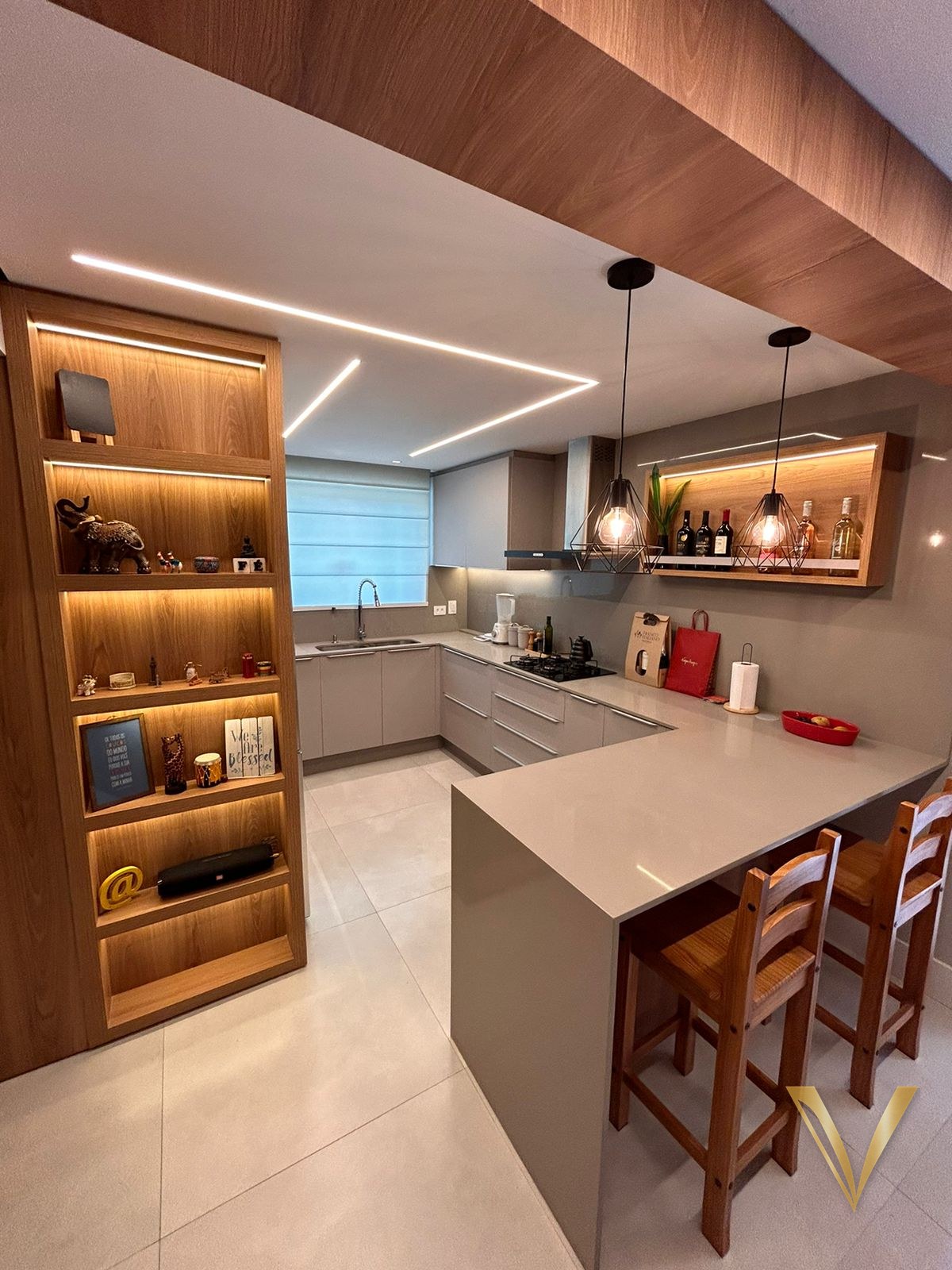 Cozinha integrada com estante vitrine iluminada, bancada em U e península de refeições