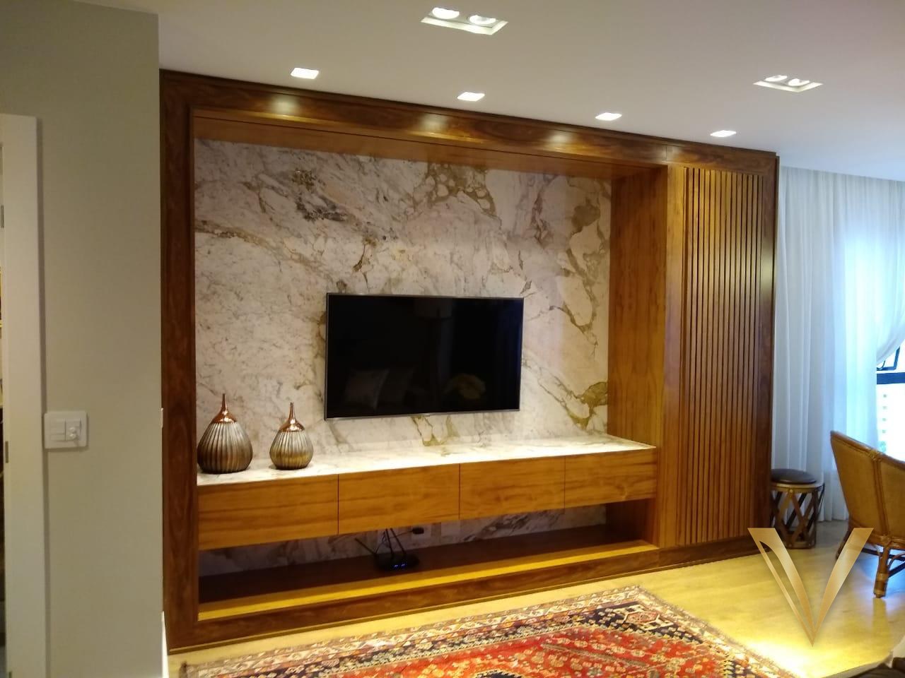 Painel de TV em pedra natural emoldurado por madeira e painel ripado lateral