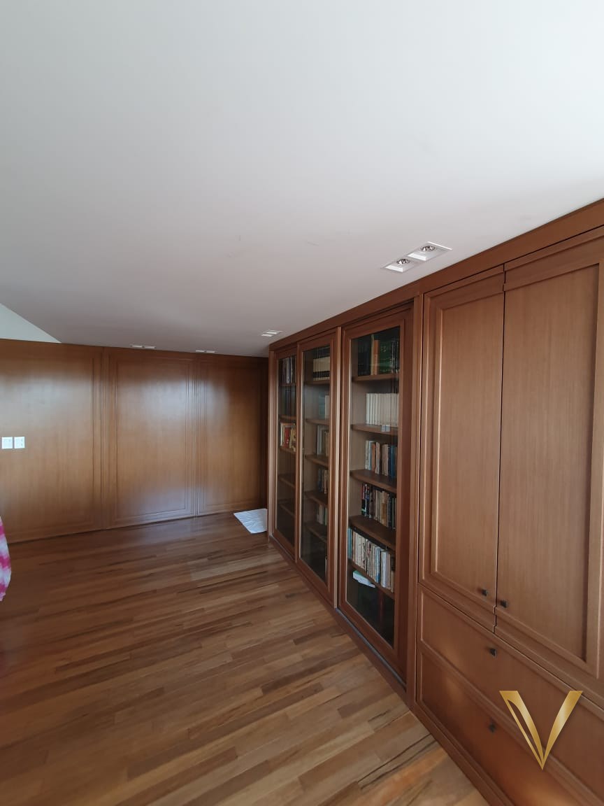 Biblioteca clássica em madeira nobre com vitrines em vidro e lambri de parede