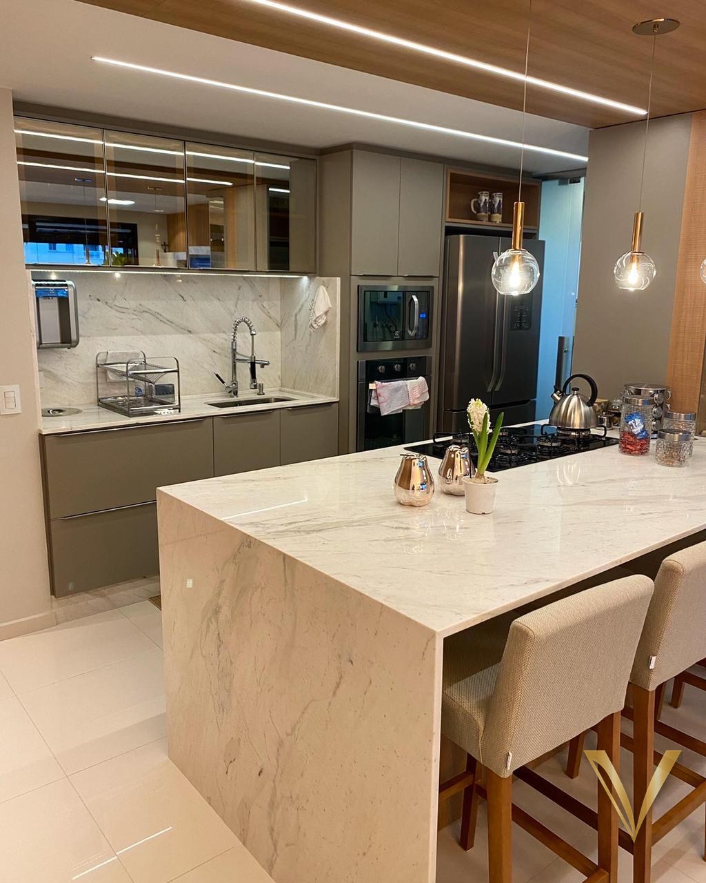 Cozinha com armários superiores em vidro bronze e frontão de mármore