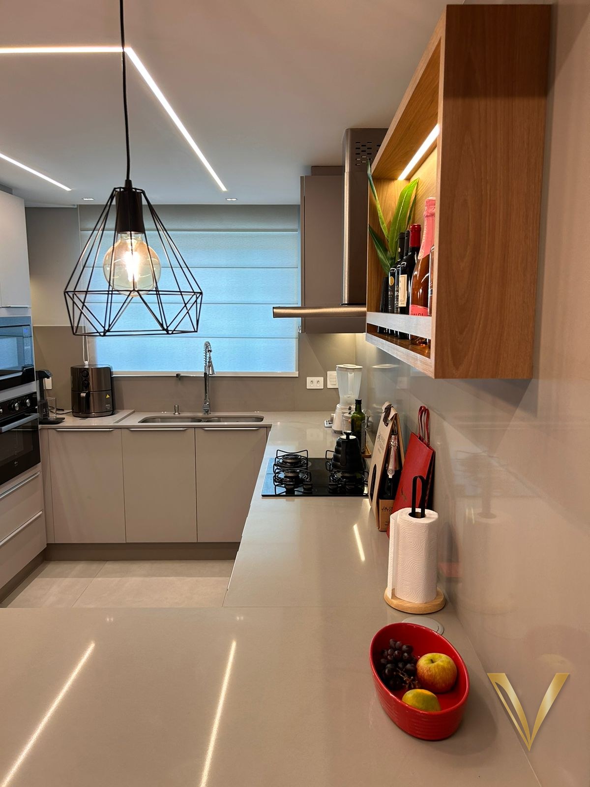 Cozinha com frentes sem puxadores, bancada clara e nicho superior em madeira iluminado