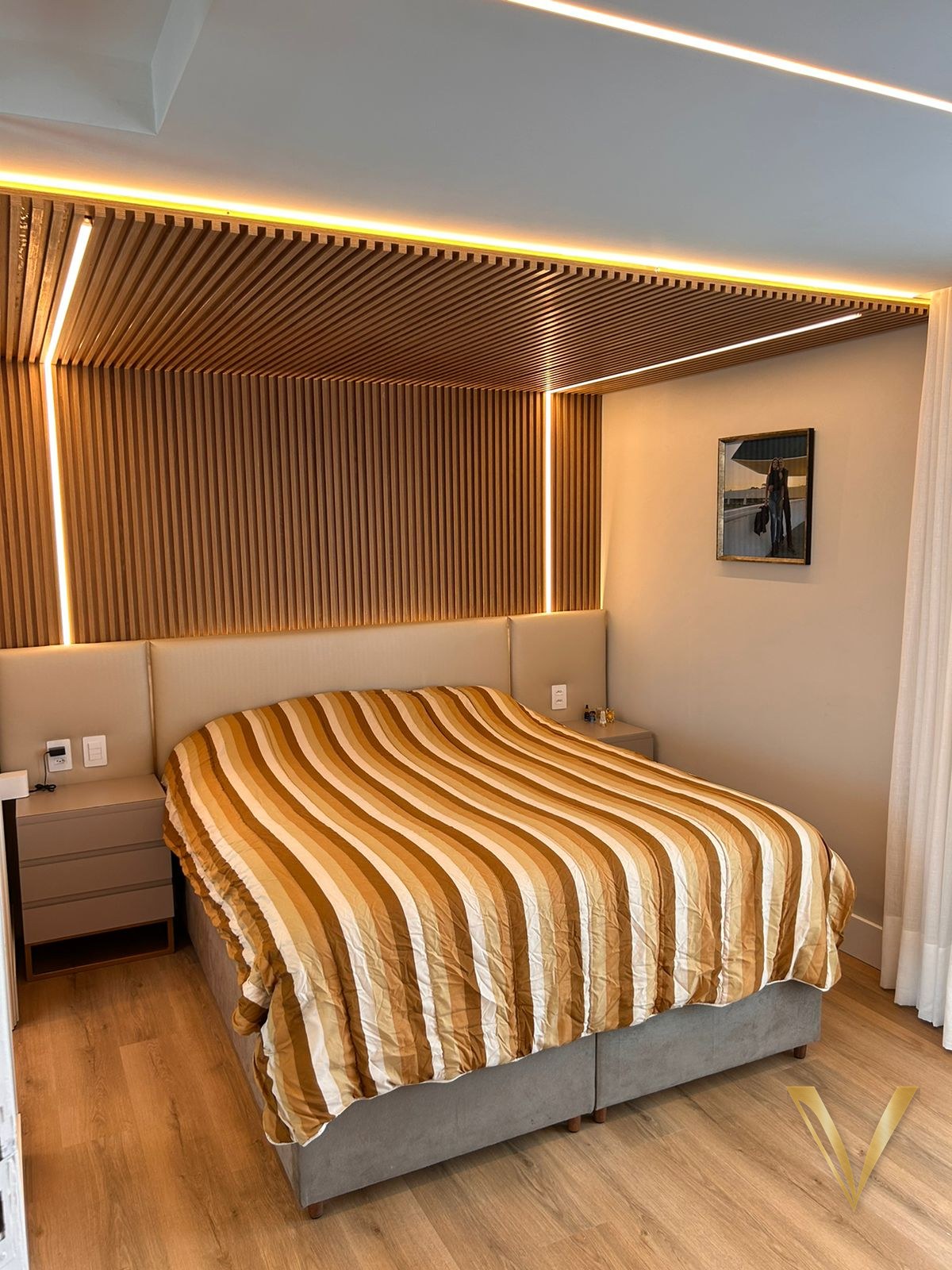 Vista do ripado de madeira iluminado sobre a cabeceira da suíte