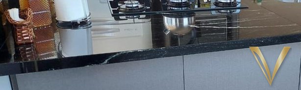 Detalhe aproximado do tampo em granito preto e do puxador em perfil embutido